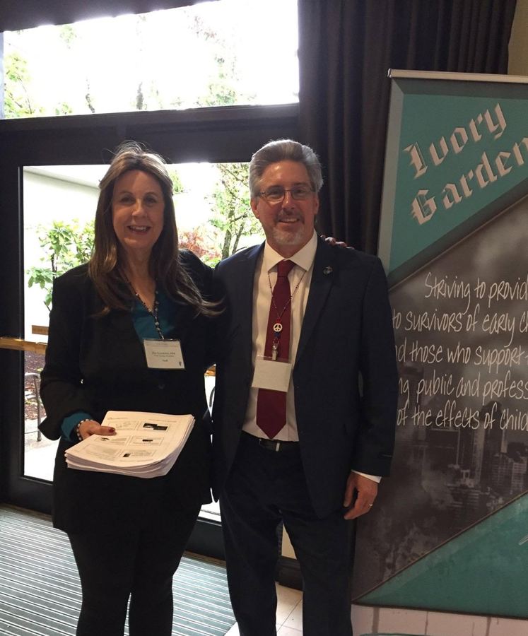 Felicity Lee and Jerome Elam standing beside the Ivory Garden banner at one of our conferences